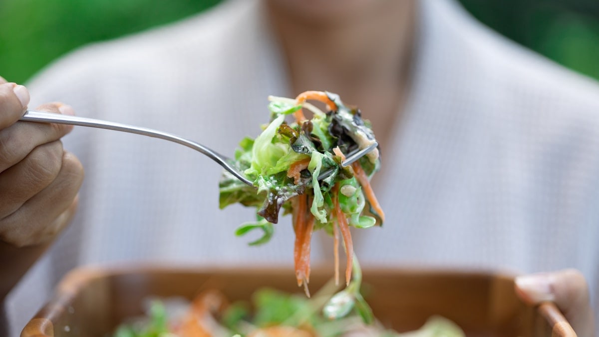 a person eating a salad with a fork